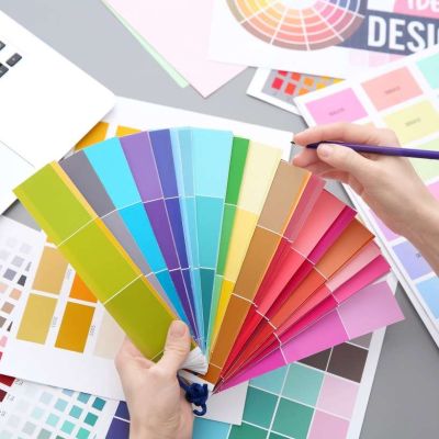 Young designer choosing color of interior while working in offic