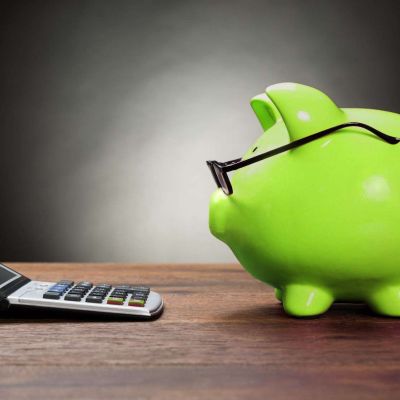 41236520 - piggybank with eyeglasses and calculator on wooden table